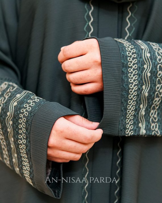 Detailed view of geometric satin embroidery pattern on sleeve cuff