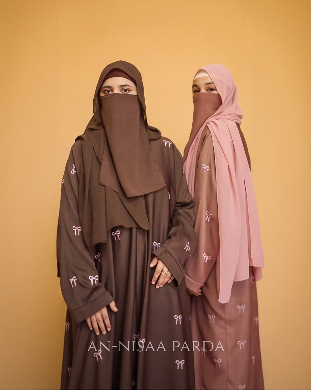 Two girls wearing bow embroidered gowns in different colors, full-length view