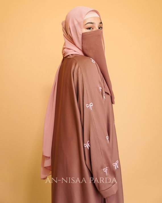 Upper body view of gown with embroidered bows, simple neckline and sleeves