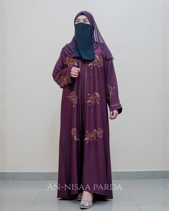 An embroidered gown with vine detailing on bodice and sleeves.