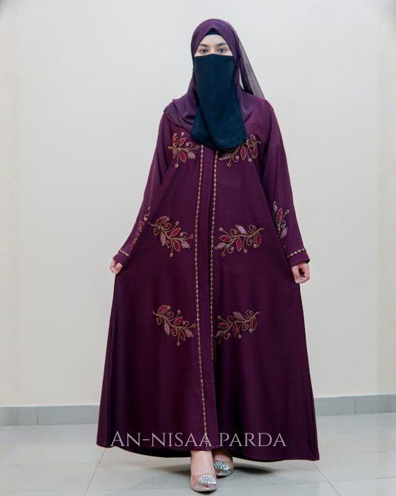 An embroidered gown with vine detailing on bodice and sleeves.