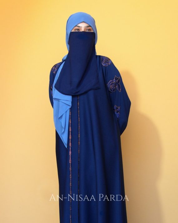 Full-length view of model wearing rosette embroidered gown with long sleeves and floor-length silhouette.